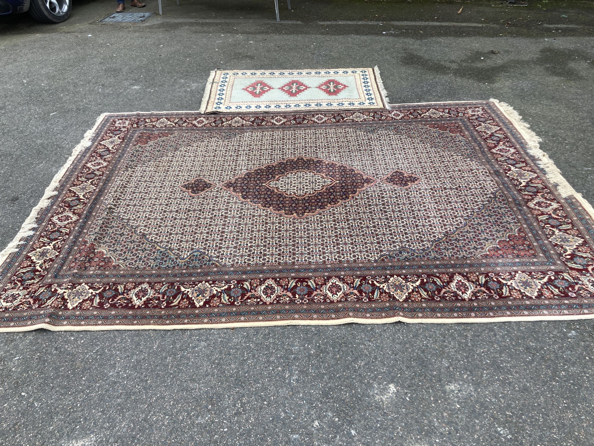 A Chinese Tabriz style carpet having burgundy central medallion on a foliate ivory ground, and a small Turkish rug